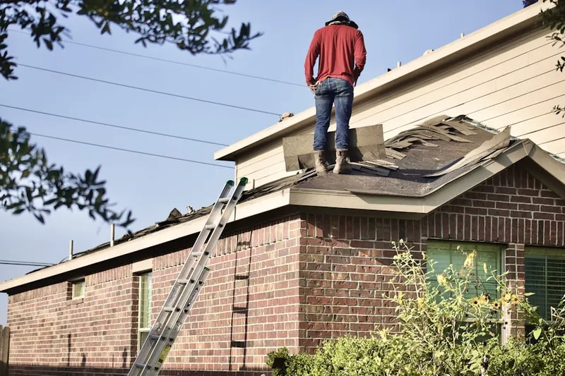 Professional roofer working on a residential roof in River Glen
